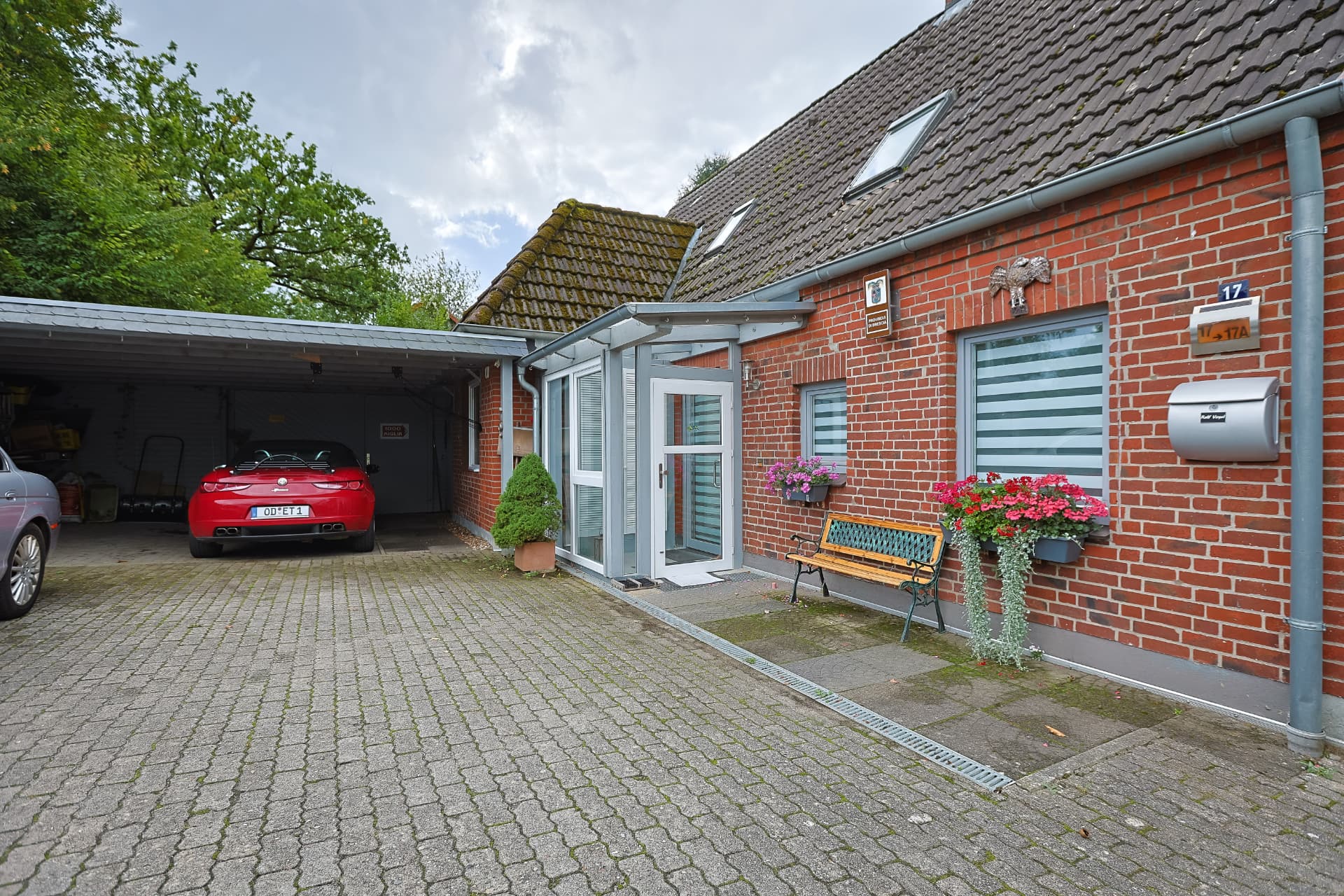 Vermietetes Backsteinhaus mit Hausnummer 17, Wintergarten-Eingang, Doppelcarport und Garage