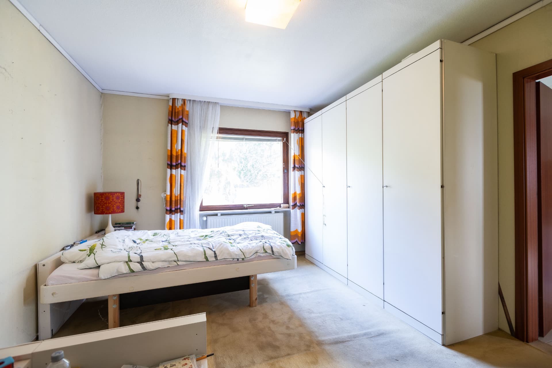 Schlafzimmer mit Einbauschränken und Fenster zum Garten