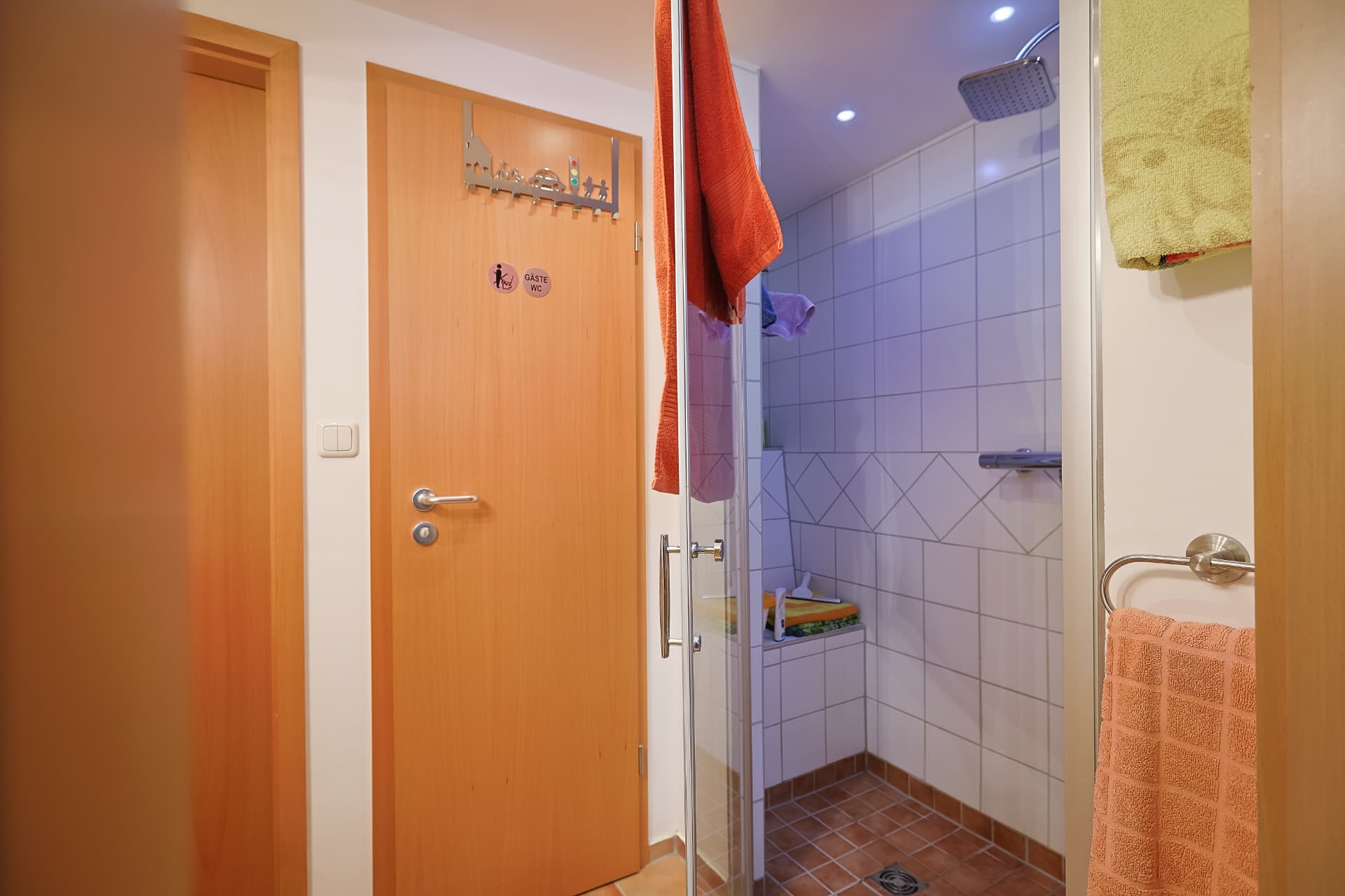 Gäste-WC mit Dusche und hellen Fliesen