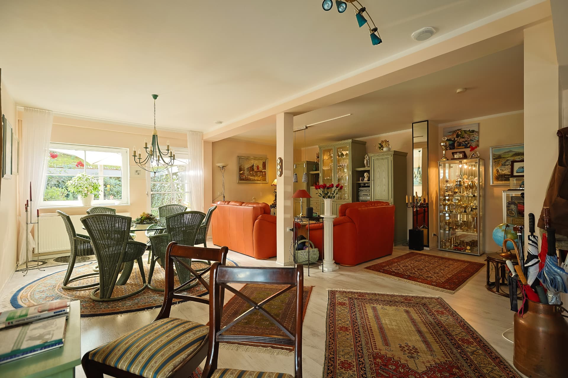Wohn- und Essbereich des vermieteten Hauses mit Chaiselongue und Vitrine
