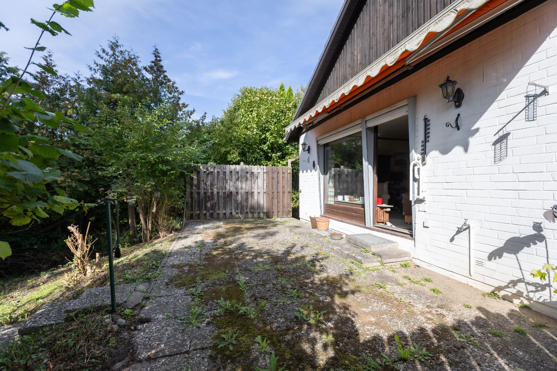 Terrasse an der Hausseite mit Markise und Zugang zum Wohnraum