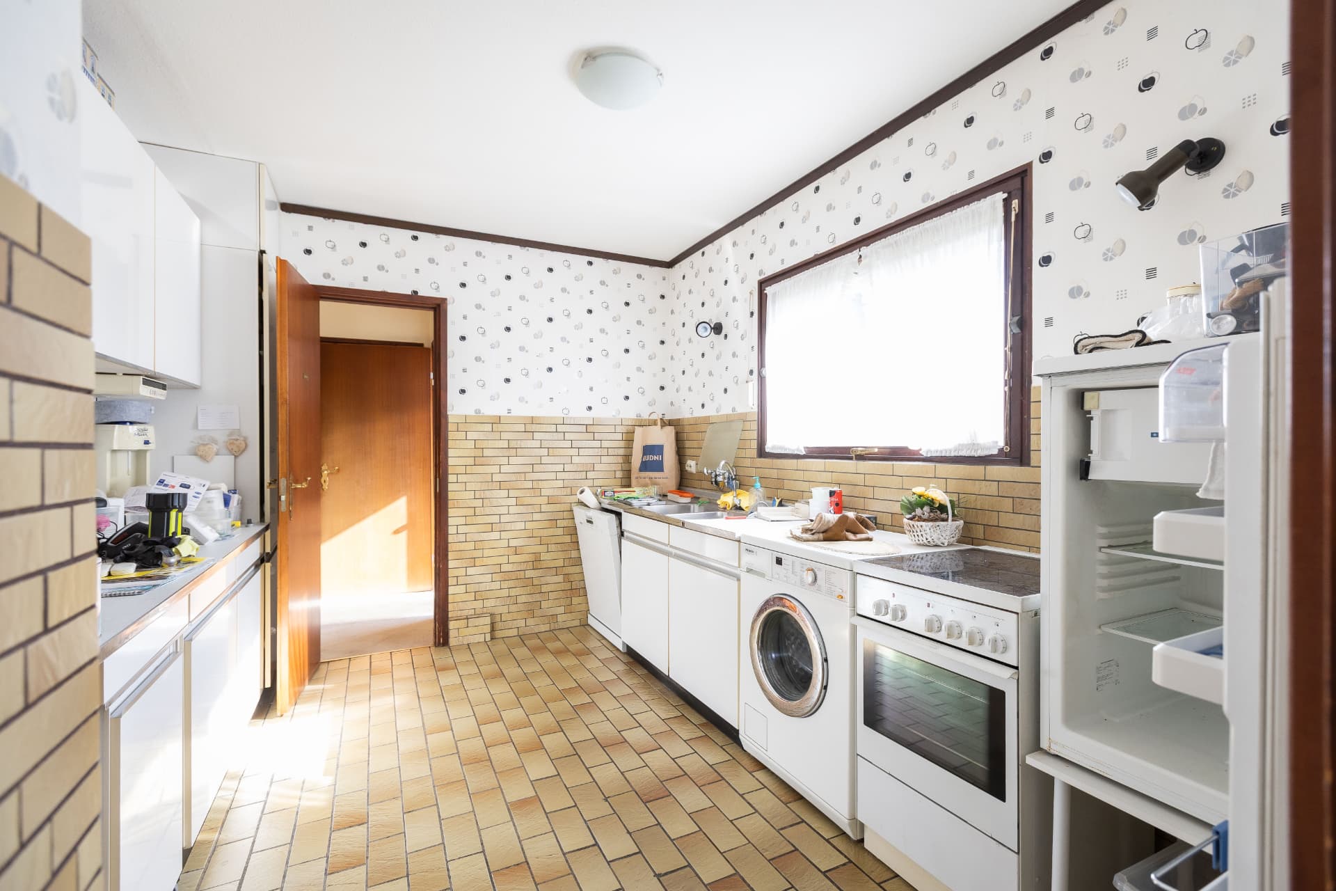 Küche mit Fenster, Einbauzeile und Fliesenspiegel
